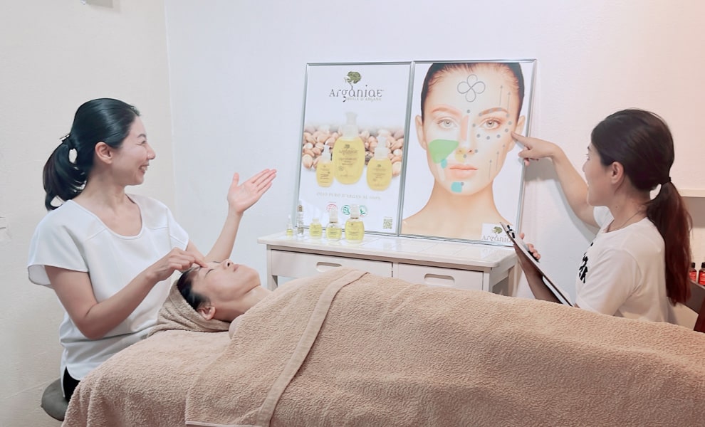 フェイシャルのチャートを見ながら説明するIMSIスタッフ