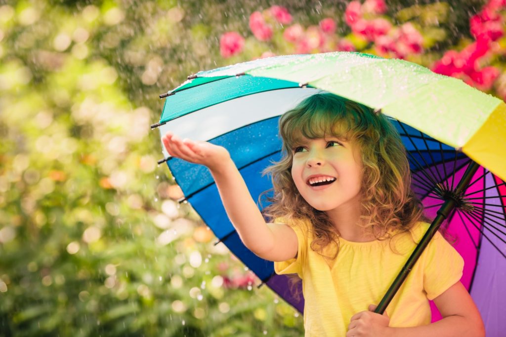 レインボーの傘をさしている女の子